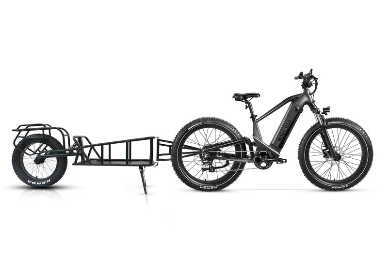 Black Magicycle Deer e-bike with cargo trailer for versatile outdoor adventures.