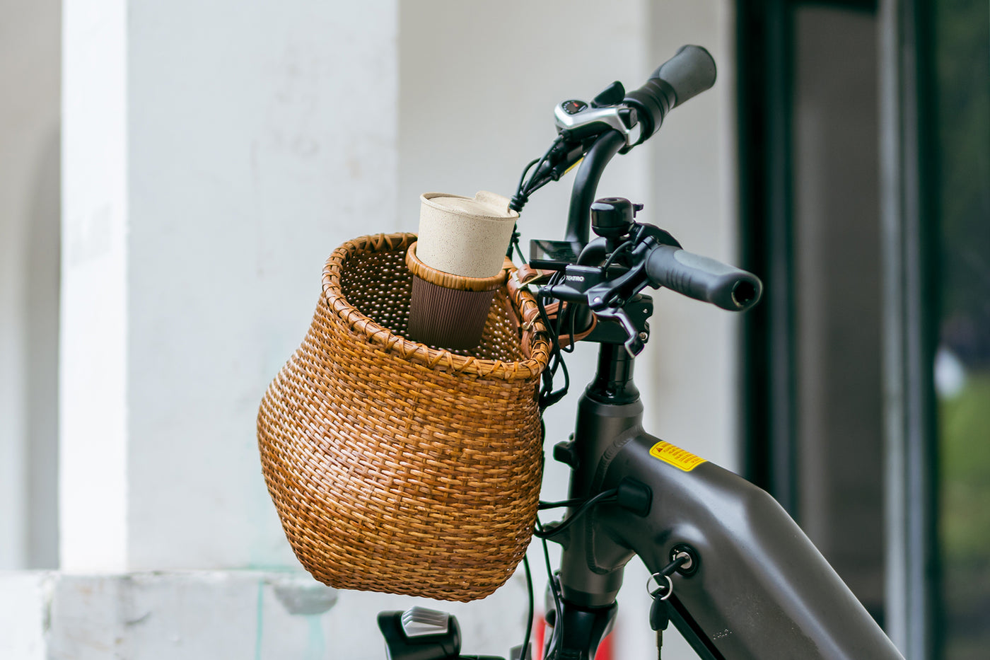 Stylish wicker bike basket with cup holder and straps on handlebars