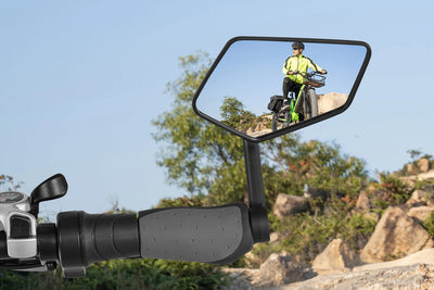 Extra-large ebike mirror showing cyclist in bright yellow jacket on rocky path.