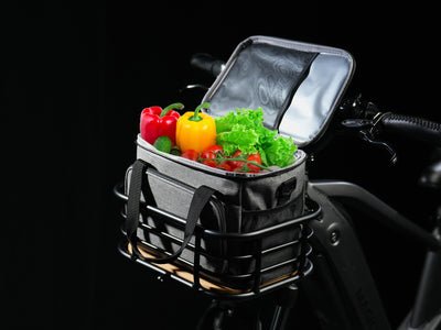 Bicycle front basket filled with fresh vegetables on a dark background
