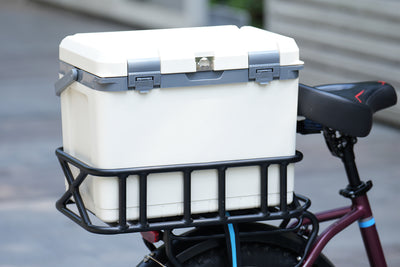 Hard cooler mounted on e-bike rear rack for outdoor picnics and adventures.