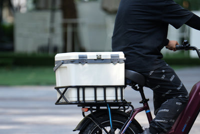 Insulated hard cooler on an e-bike, ideal for outdoor trips and tailgating.