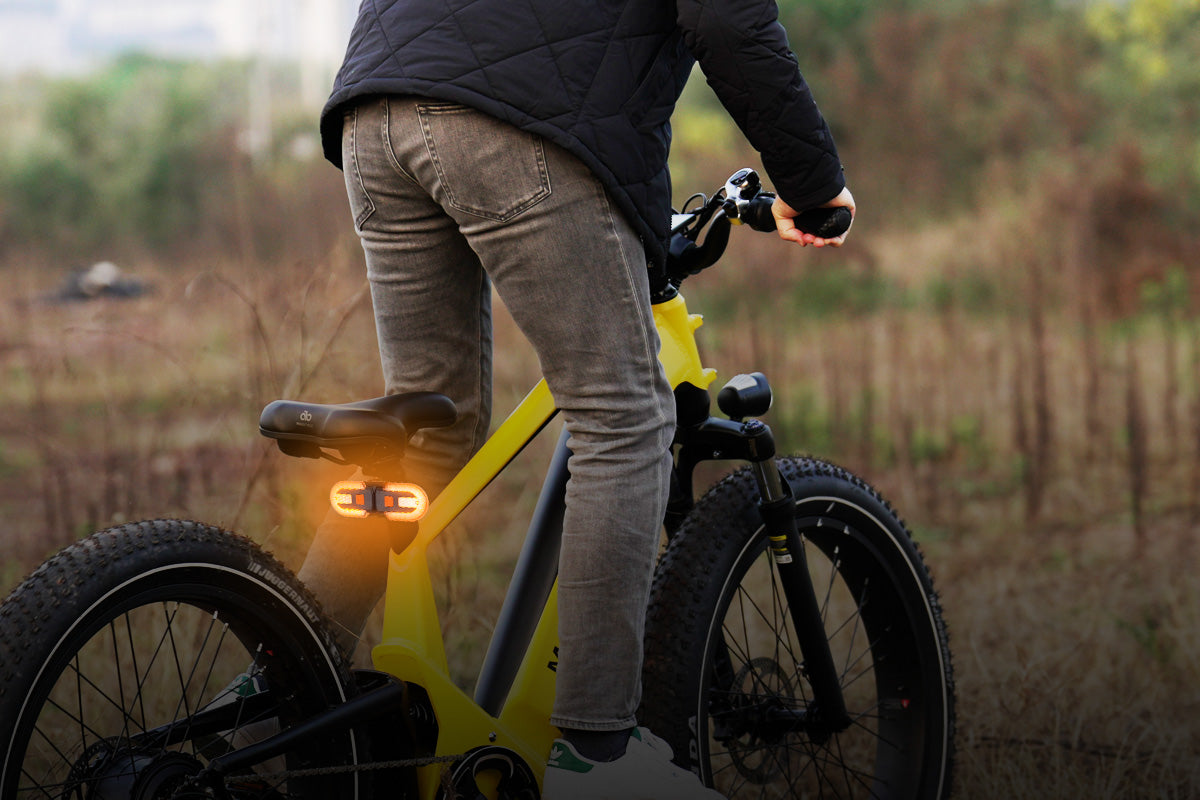 Rider using electric bike tail light with turn signals during a ride