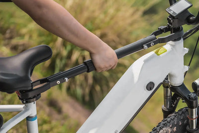 Person using Cross-Bar Adjustable Adapter for e-bike transport.