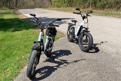 Magicycle electric bikes parked on a road with lush greenery, ideal for outdoor adventures.