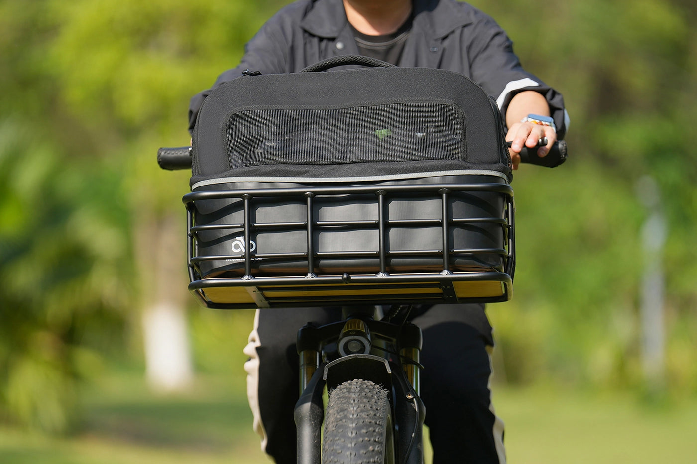 Black Magicycle pet carrier securely attached to bike basket, designed for small pets.